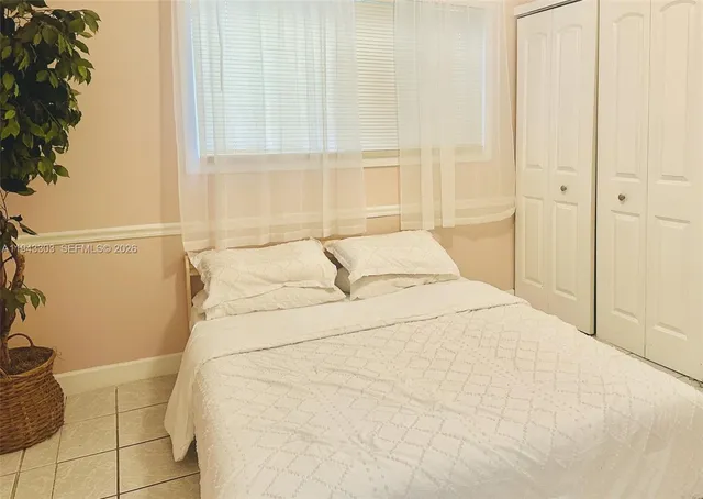 a large white bed in a bathroom next to a window