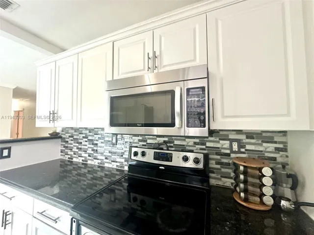 a kitchen with a stove a sink and a microwave