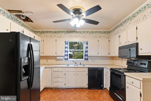 a kitchen with a sink stainless steel appliances and white cabinets