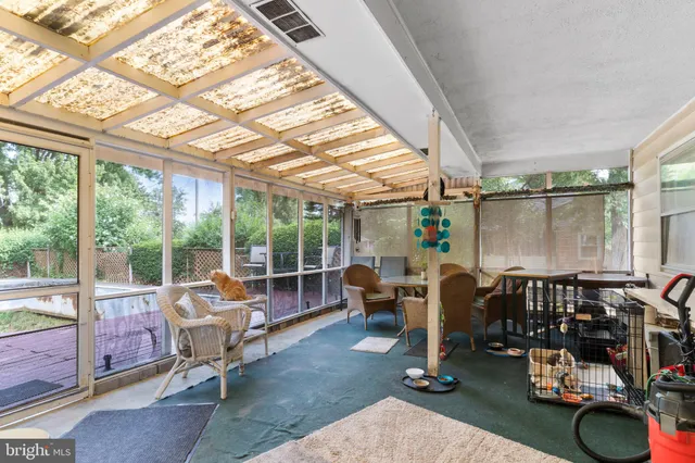 a living room with patio furniture and a floor to ceiling window