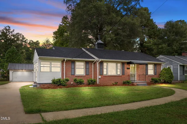 a front view of a house with a garden and yard