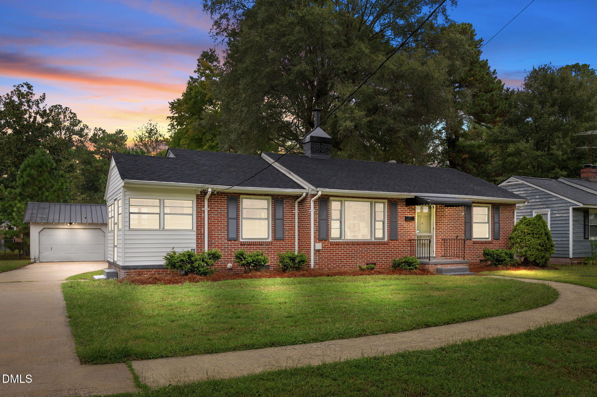 a front view of a house with a garden and yard