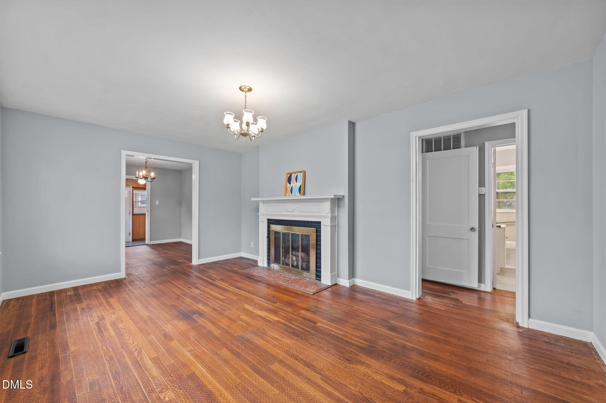1220 Tarboro Street Rocky Mount, NC 27801 - Photo 16 of 47 a view of an empty room with wooden floor fireplace and a window