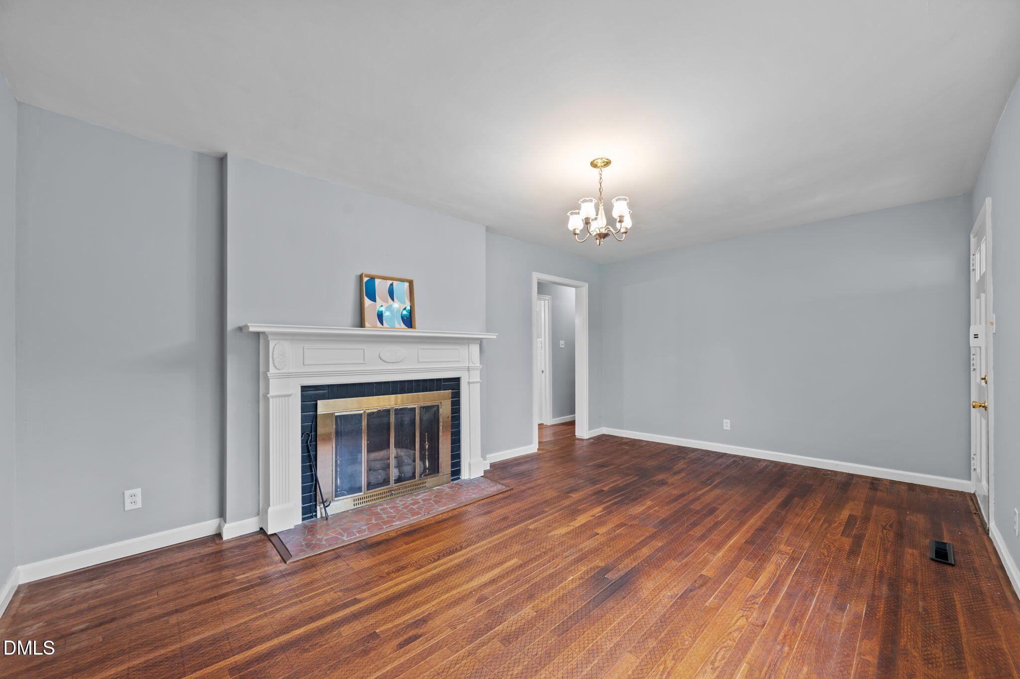 1220 Tarboro Street Rocky Mount, NC 27801 - Photo 18 of 47 a view of an empty room with wooden floor fireplace and a window
