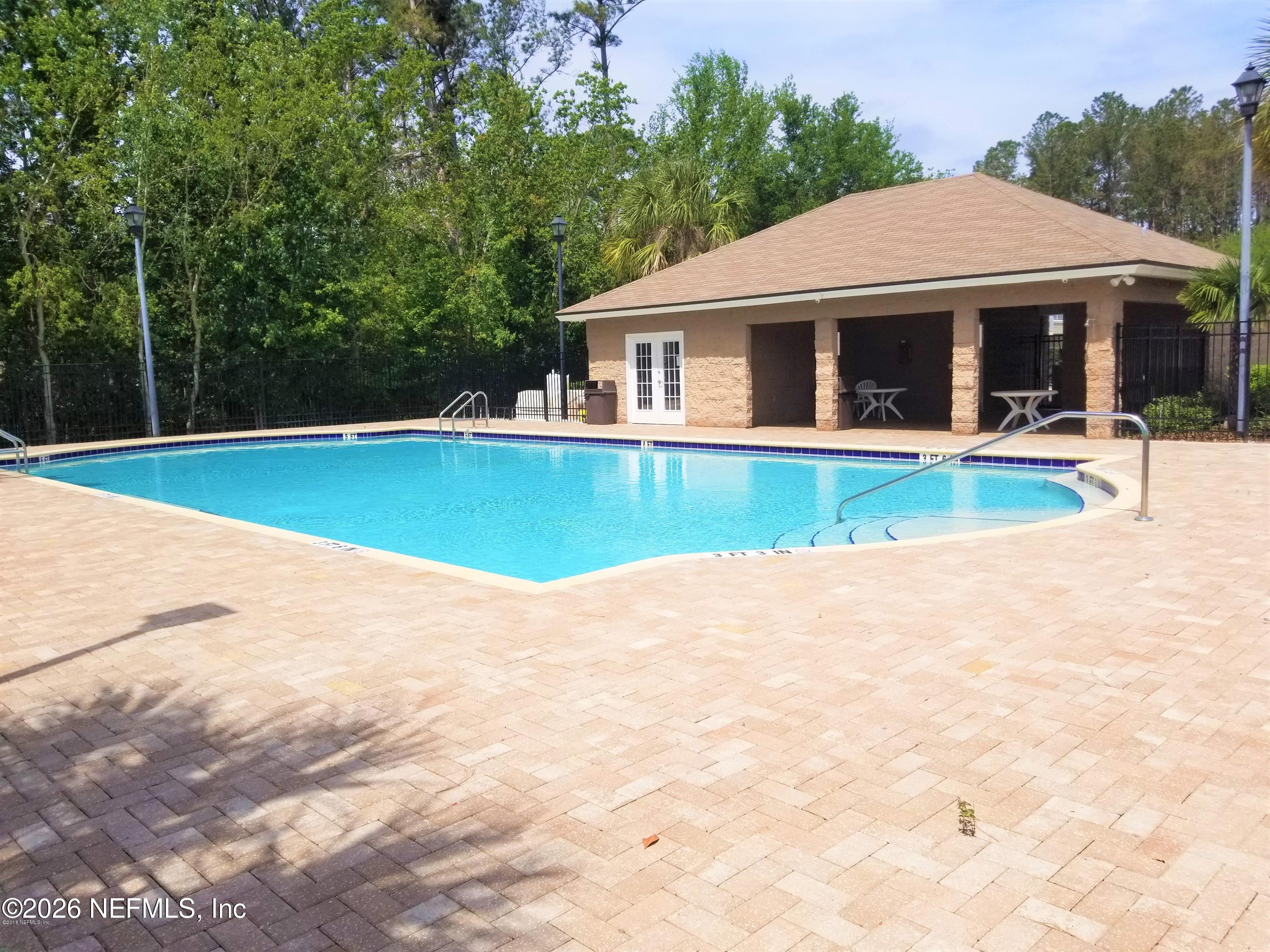 7920 Merrill Road, Unit 2004 Jacksonville, FL 32277 - Photo 12 of 13 a view of a house with pool and a yard