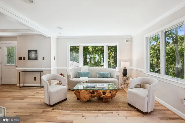 a kitchen with stainless steel appliances kitchen island granite countertop a refrigerator a sink dishwasher a stove and white cabinets with wooden floor