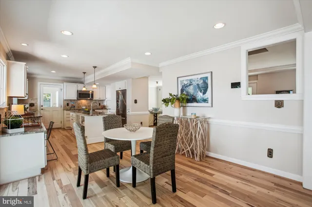 a living room with furniture large window and wooden floor