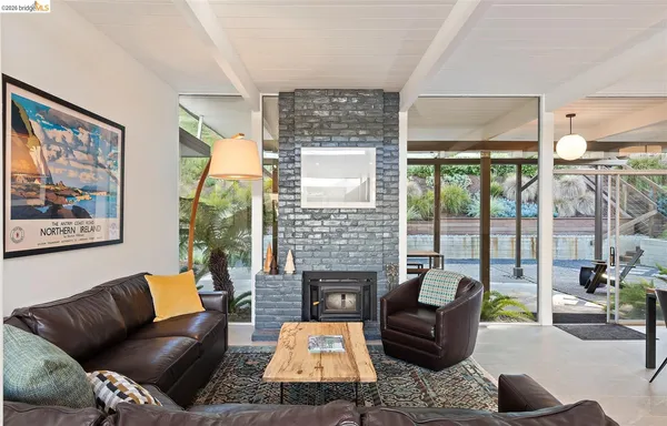 a living room with furniture a fireplace and a floor to ceiling window