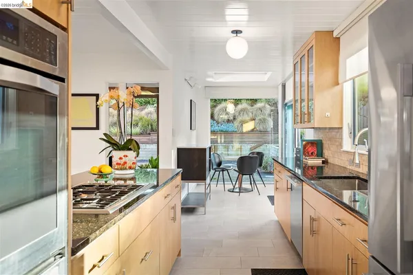 a living room with stainless steel appliances kitchen island granite countertop furniture and a large window