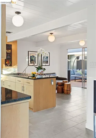 a dining hall with granite countertop a refrigerator and cabinets