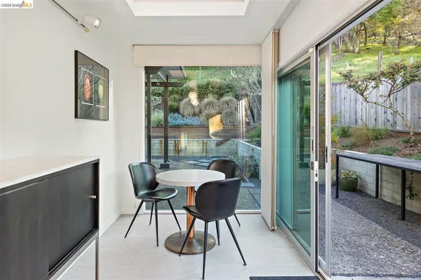 a dining room with furniture and a floor to ceiling window