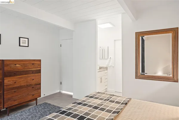 a bedroom with a large bed and a potted plant