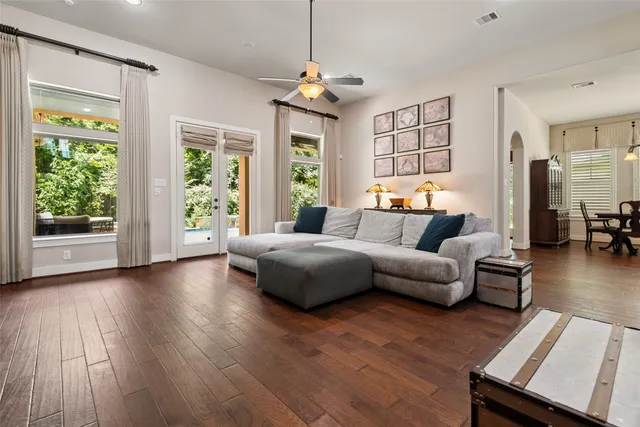 a spacious bedroom with wooden floors and a large window