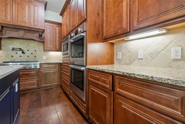 a kitchen with stainless steel appliances granite countertop a stove a sink and dishwasher