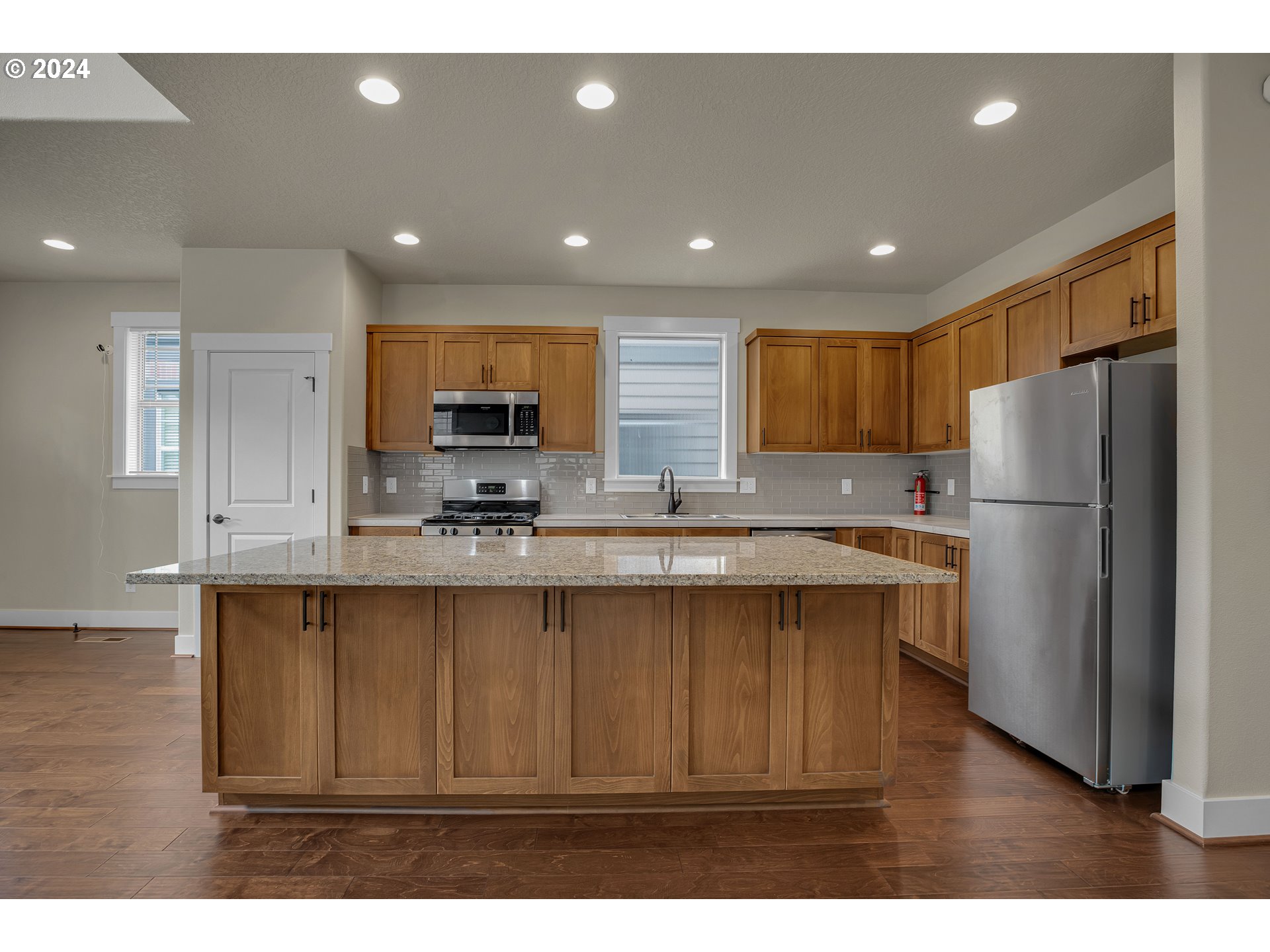 16937 Southwest Friendly Lane Beaverton, OR 97007 - Photo 11 of 44 a kitchen with refrigerator cabinets and wooden floor
