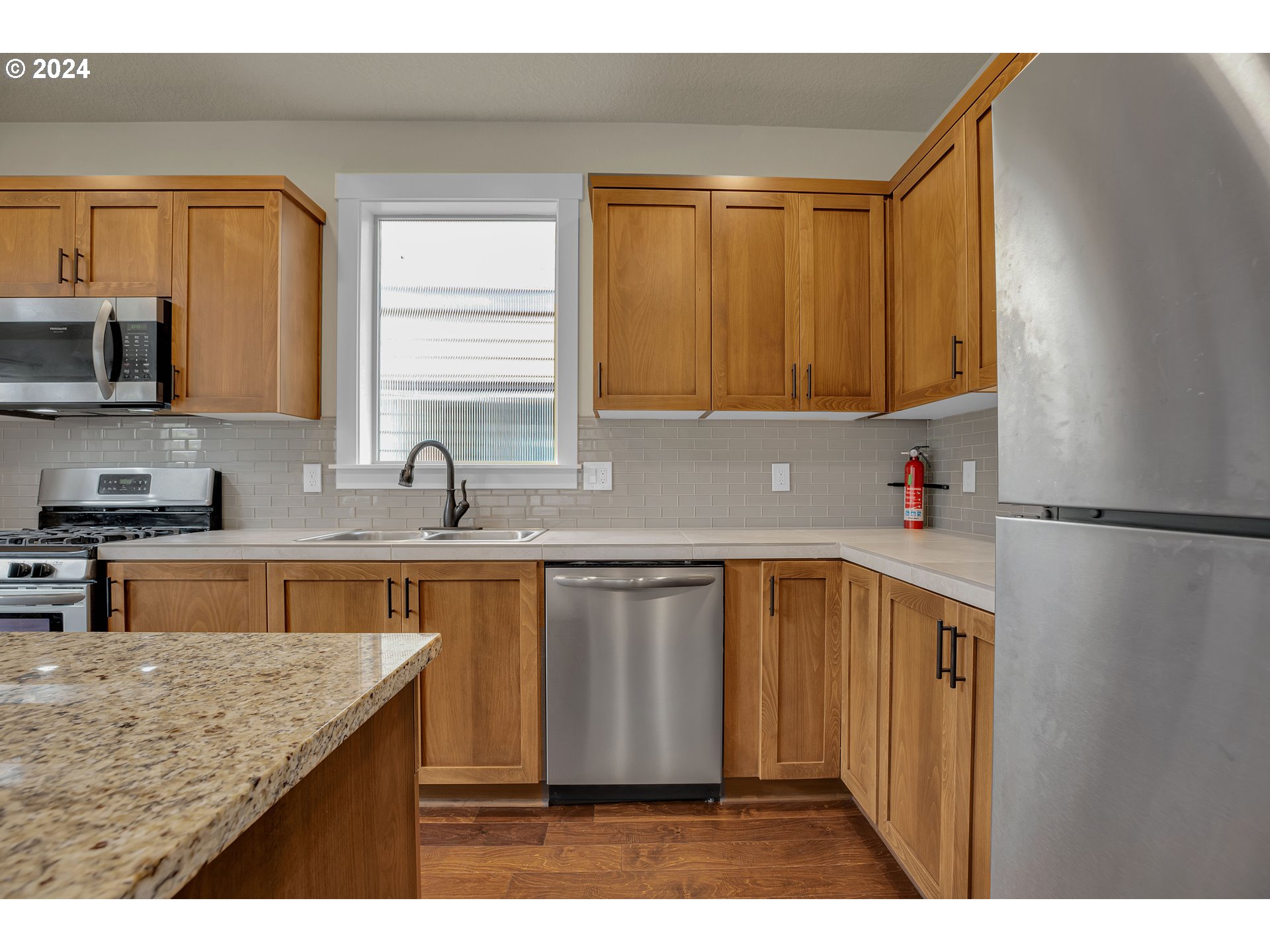 16937 Southwest Friendly Lane Beaverton, OR 97007 - Photo 12 of 44 a kitchen with stainless steel appliances granite countertop a sink stove and refrigerator