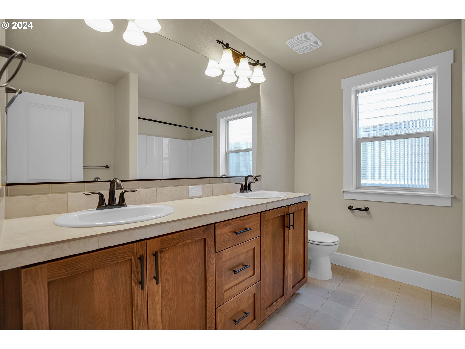 16937 Southwest Friendly Lane Beaverton, OR 97007 - Photo 32 of 44 a bathroom with a granite countertop sink a toilet and a mirror