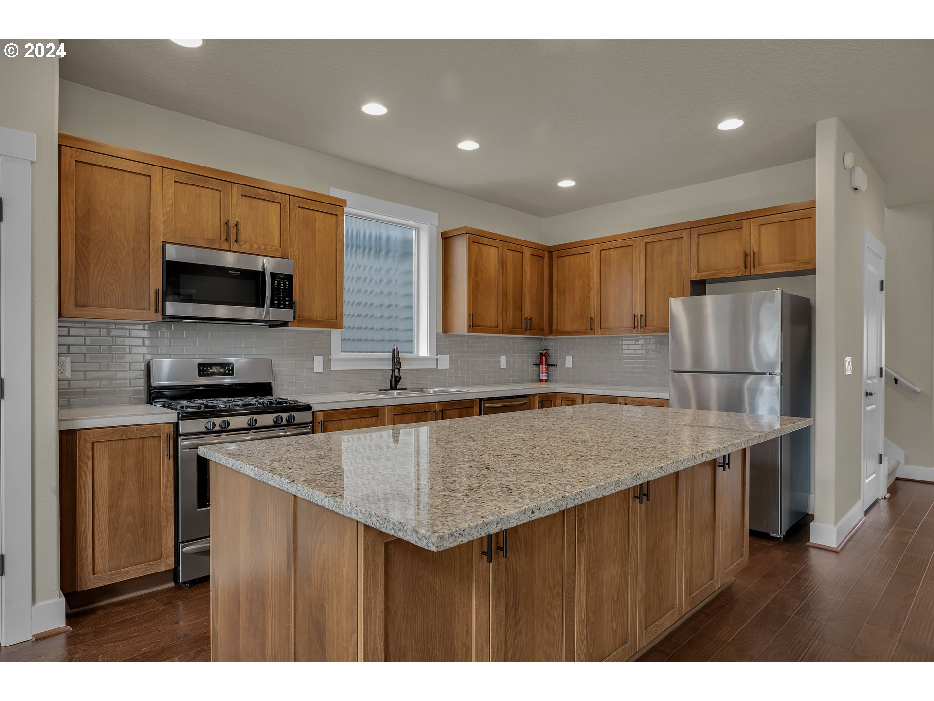 16937 Southwest Friendly Lane Beaverton, OR 97007 - Photo 9 of 44 a kitchen with stainless steel appliances granite countertop a sink stove microwave and refrigerator