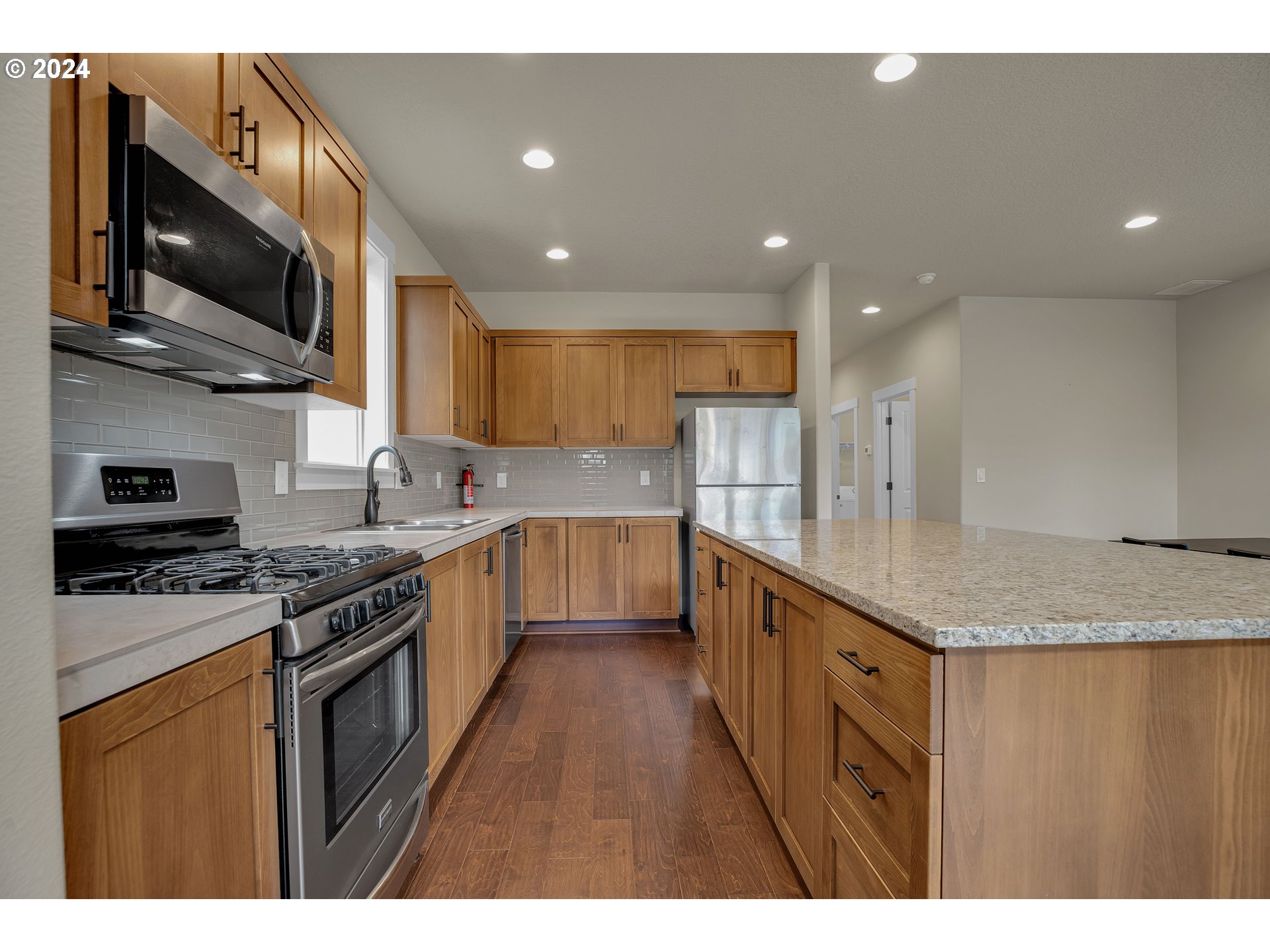 16937 Southwest Friendly Lane Beaverton, OR 97007 - Photo 10 of 44 a kitchen with stainless steel appliances granite countertop a stove a sink and a refrigerator