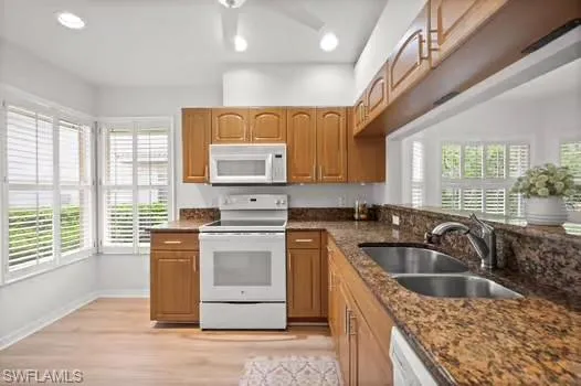 a kitchen that has a sink wooden cabinets and a granite counter tops