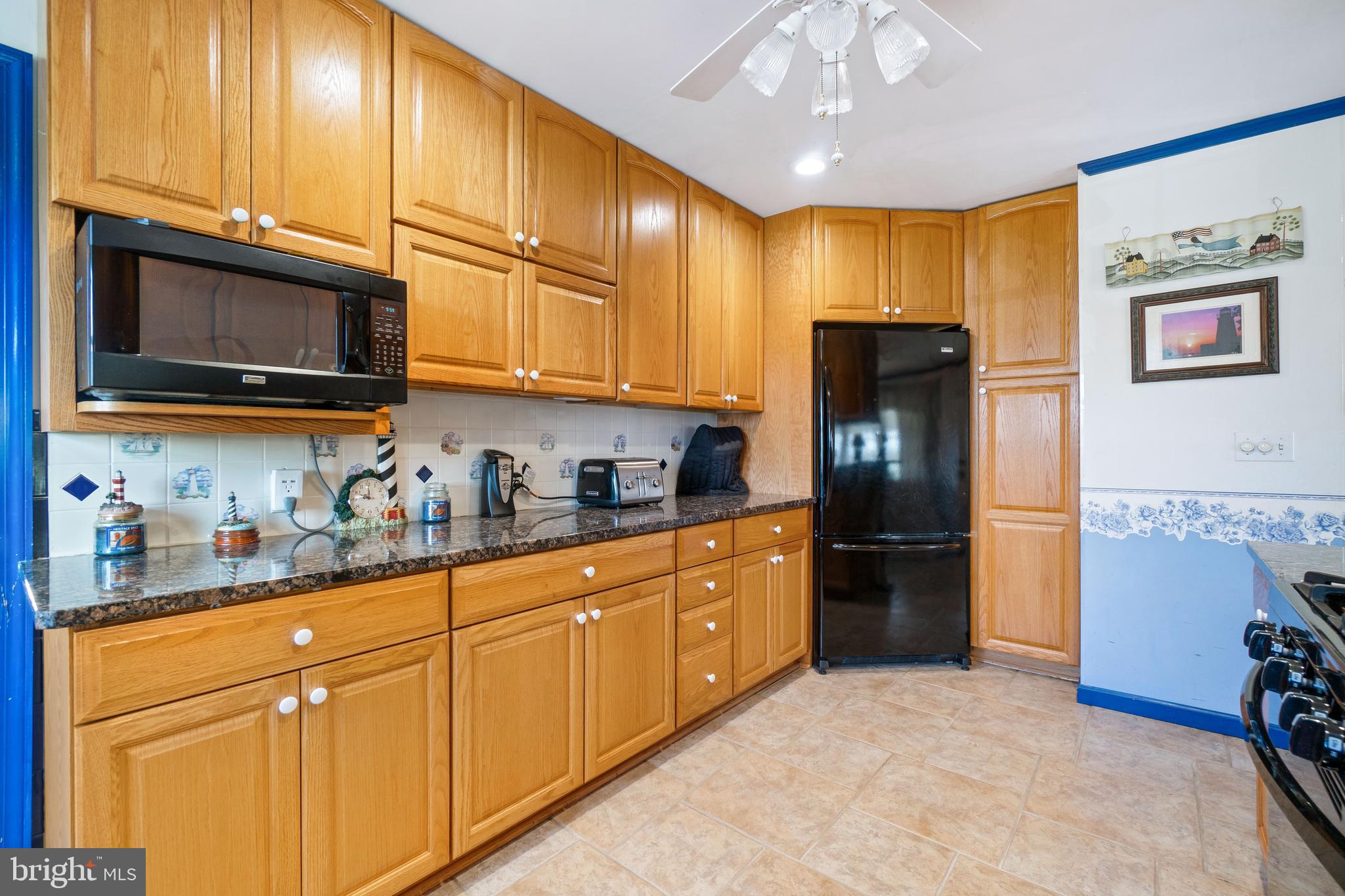 22 Peach Road Elkton, MD 21921 - Photo 9 of 24 a kitchen with stainless steel appliances granite countertop a refrigerator a stove a sink dishwasher and wooden cabinets with a dining table