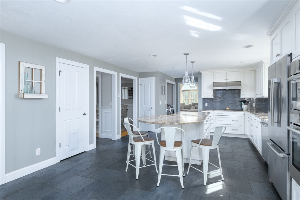 27 Vista Circle Rutland, MA 01543 - Photo 3 of 35 a kitchen with stainless steel appliances kitchen island granite countertop a dining table chairs and a refrigerator