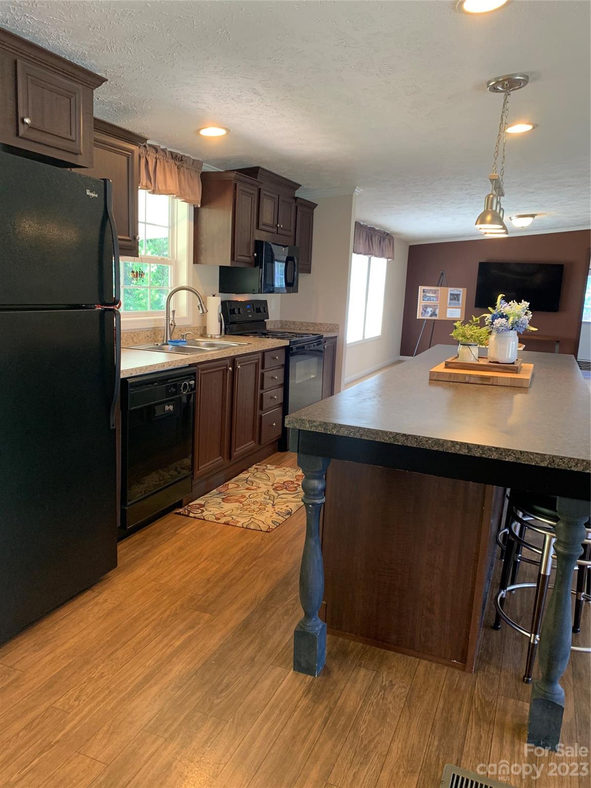 2380 Briggs Road Salisbury, NC 28147 - Photo 3 of 27 a kitchen with kitchen island a counter top space a sink a refrigerator and a stove