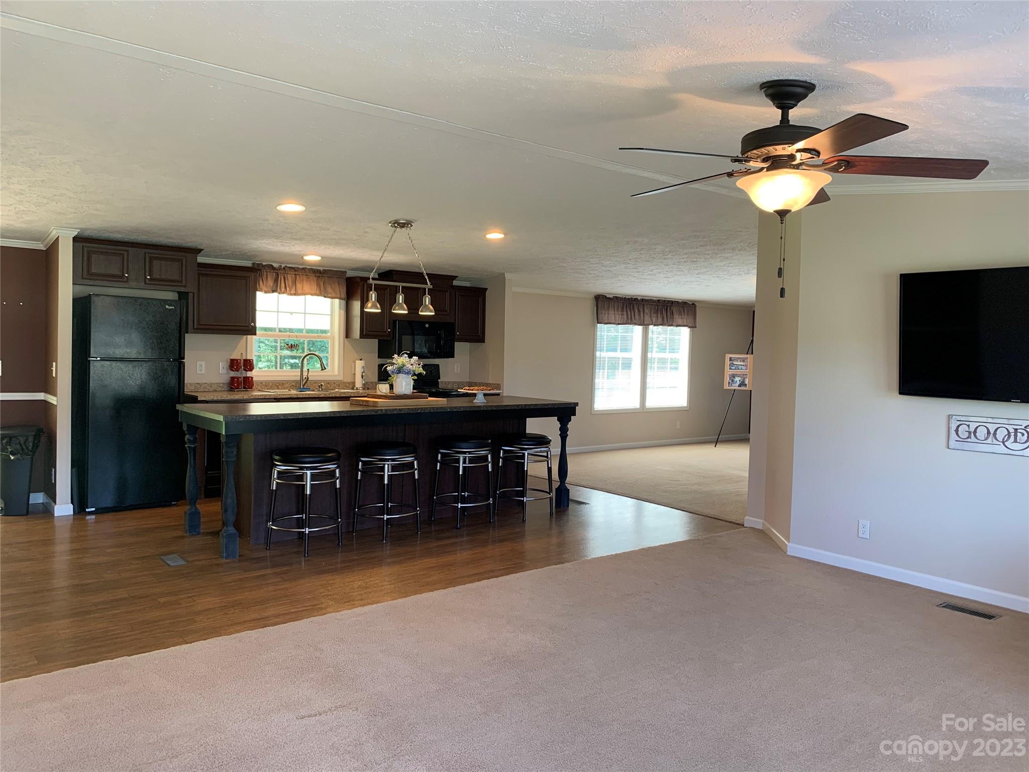 2380 Briggs Road Salisbury, NC 28147 - Photo 4 of 27 a kitchen with stainless steel appliances kitchen island granite countertop a refrigerator a sink a stove and a dining table with wooden floor