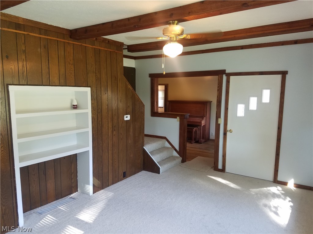 4695 Middle Ridge Road Perry, OH 44081 - Photo 14 of 28 Other view of living room. Master bedroom entrance is to the left of the book shelf. Stairs leading up go to two bedrooms. Hall with piano has a closet. Can us this space for kids play area or an office space.