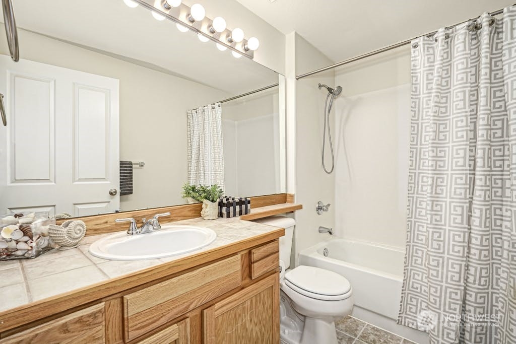 1009 112th Street Southeast, Unit E104 Everett, WA 98208 - Photo 16 of 24 a bathroom with a granite countertop sink toilet and shower