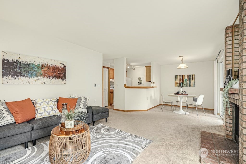 1009 112th Street Southeast, Unit E104 Everett, WA 98208 - Photo 2 of 24 a living room with furniture and a dining table with wooden floor