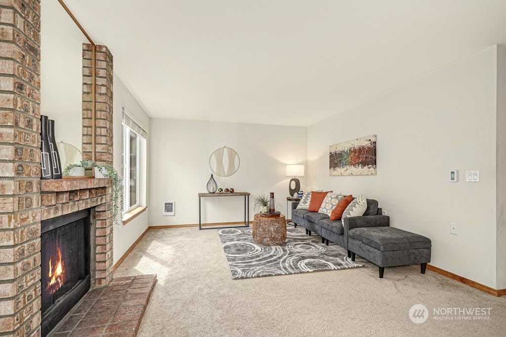 1009 112th Street Southeast, Unit E104 Everett, WA 98208 - Photo 3 of 24 a living room with furniture a fireplace and a table