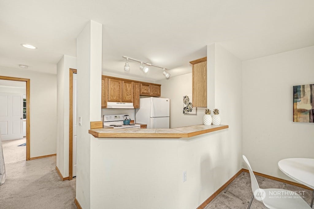 1009 112th Street Southeast, Unit E104 Everett, WA 98208 - Photo 7 of 24 a bathroom with sink a mirror a toilet and a window