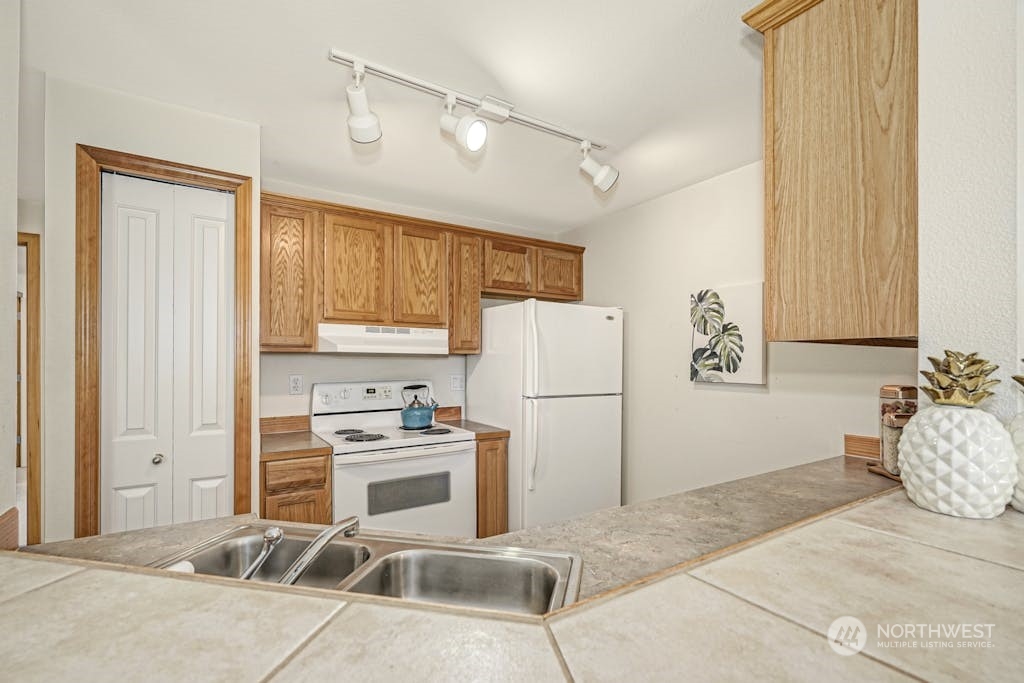 1009 112th Street Southeast, Unit E104 Everett, WA 98208 - Photo 8 of 24 a kitchen with a refrigerator sink stove and cabinets