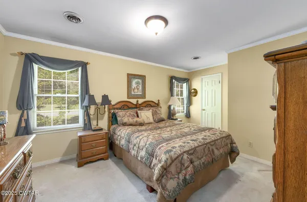 a bedroom with a bed and a dresser next to a window