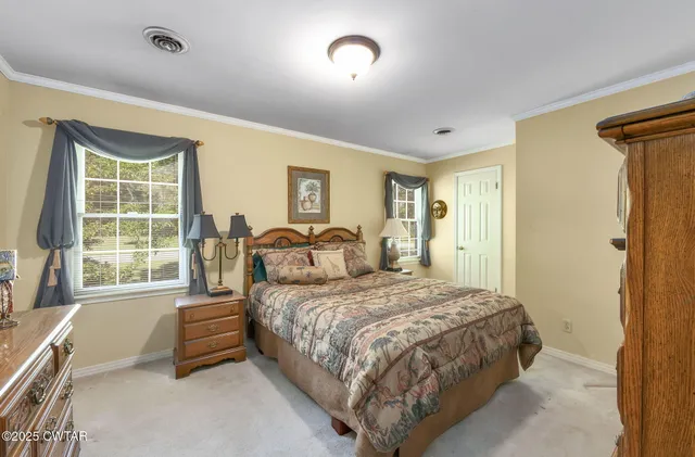a bedroom with a bed and a dresser next to a window