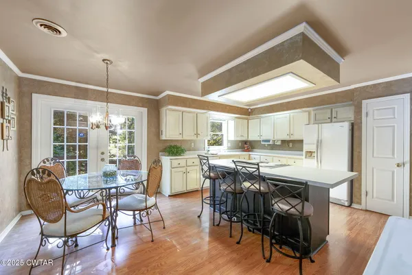 a view of a dining room and livingroom with furniture window and wooden floor