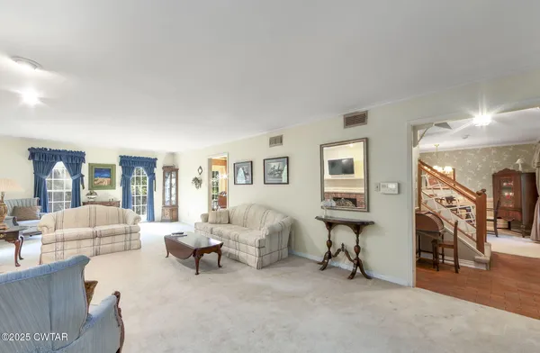 a living room with furniture and a gym machine with wooden floor