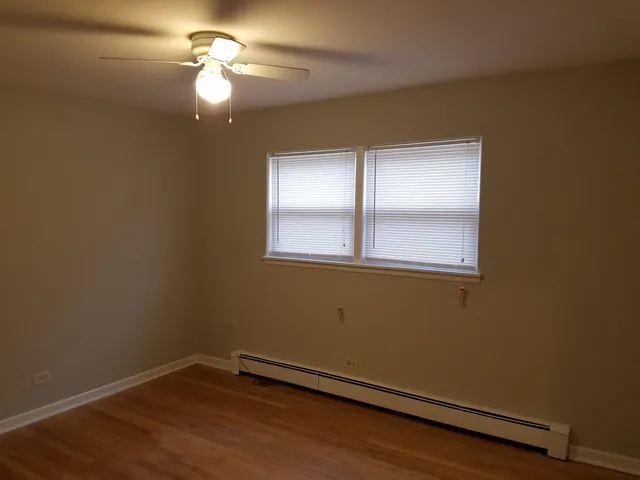 a view of a room with wooden floor and fan