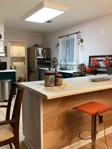 a kitchen with kitchen island a sink table and chairs