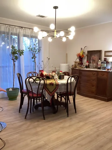 a view of a dining room with furniture and chandelier