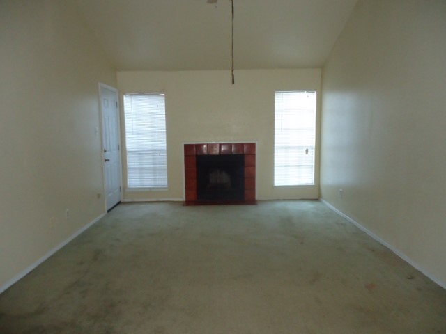 12500 Sandpiper Drive, Unit 186 Houston, TX 77035 - Photo 8 of 10 an empty room with a fireplace and windows