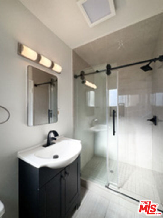 1323 South Ridgeley Drive, Unit 2 Los Angeles, CA 90019 - Photo 6 of 11 a bathroom with a sink and a mirror