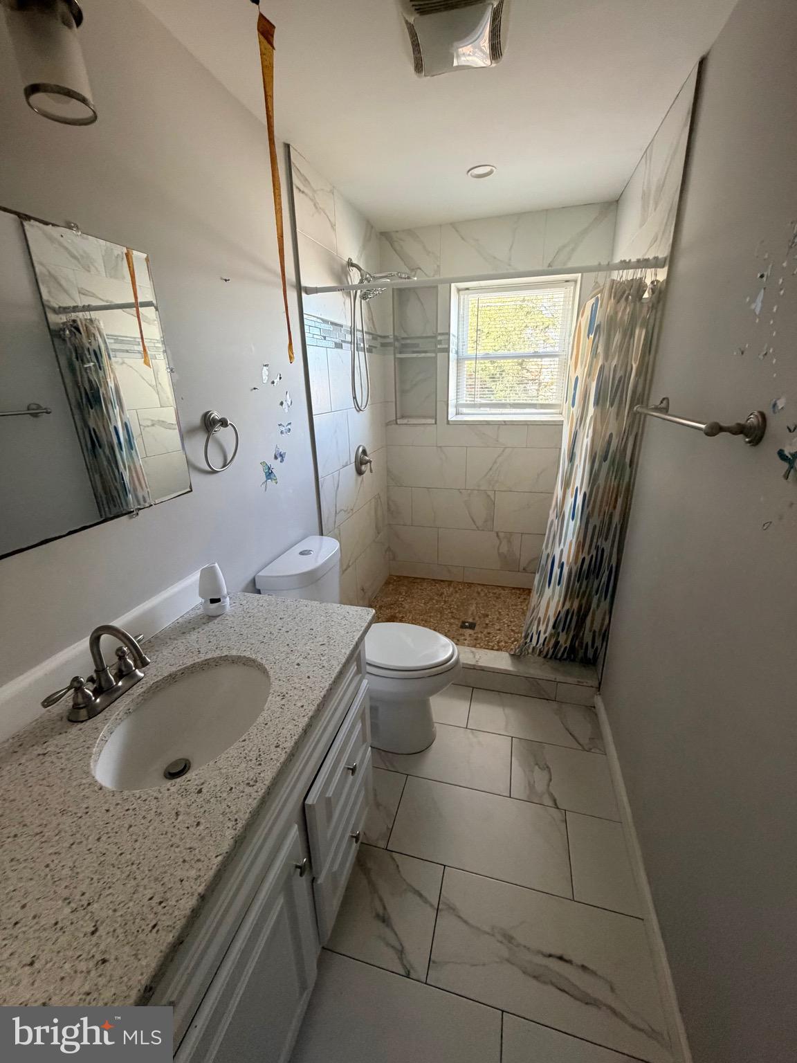 412 East Cold Spring Lane Baltimore, MD 21212 - Photo 2 of 8 a bathroom with a granite countertop sink a toilet and a mirror