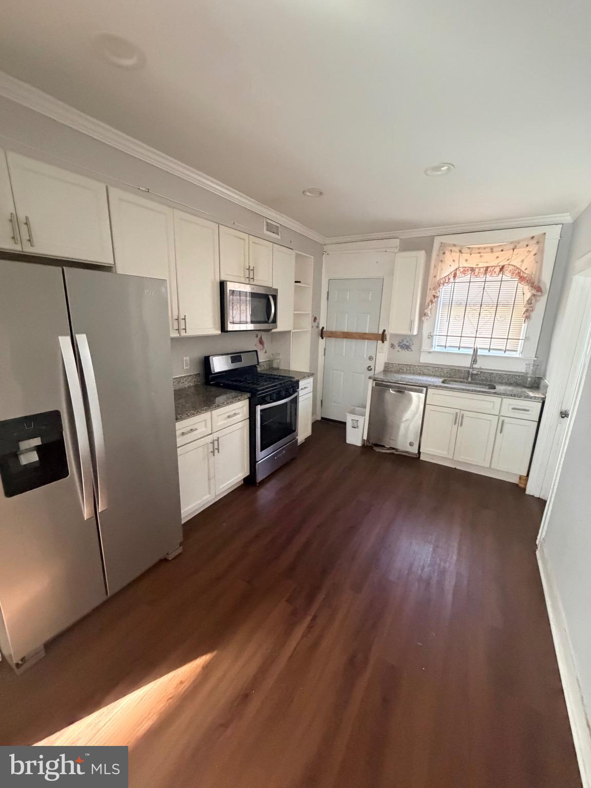 412 East Cold Spring Lane Baltimore, MD 21212 - Photo 7 of 8 a kitchen with a refrigerator a sink dishwasher stove and wooden floors