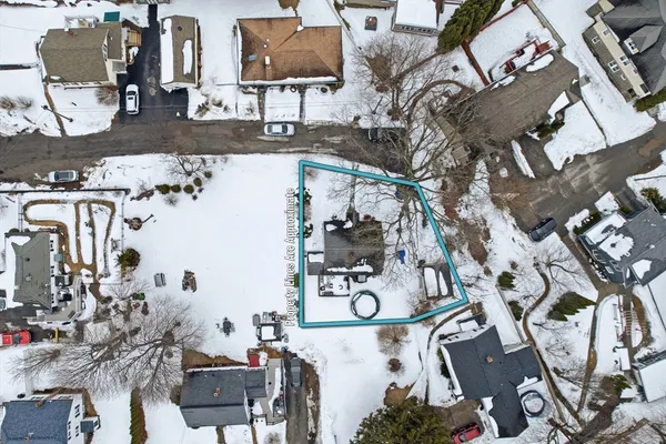 an aerial view of a house with garden space and street view