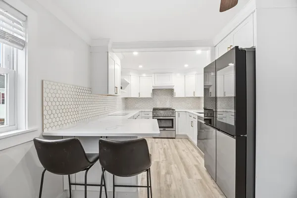 a kitchen with stainless steel appliances granite countertop a refrigerator and a stove top oven