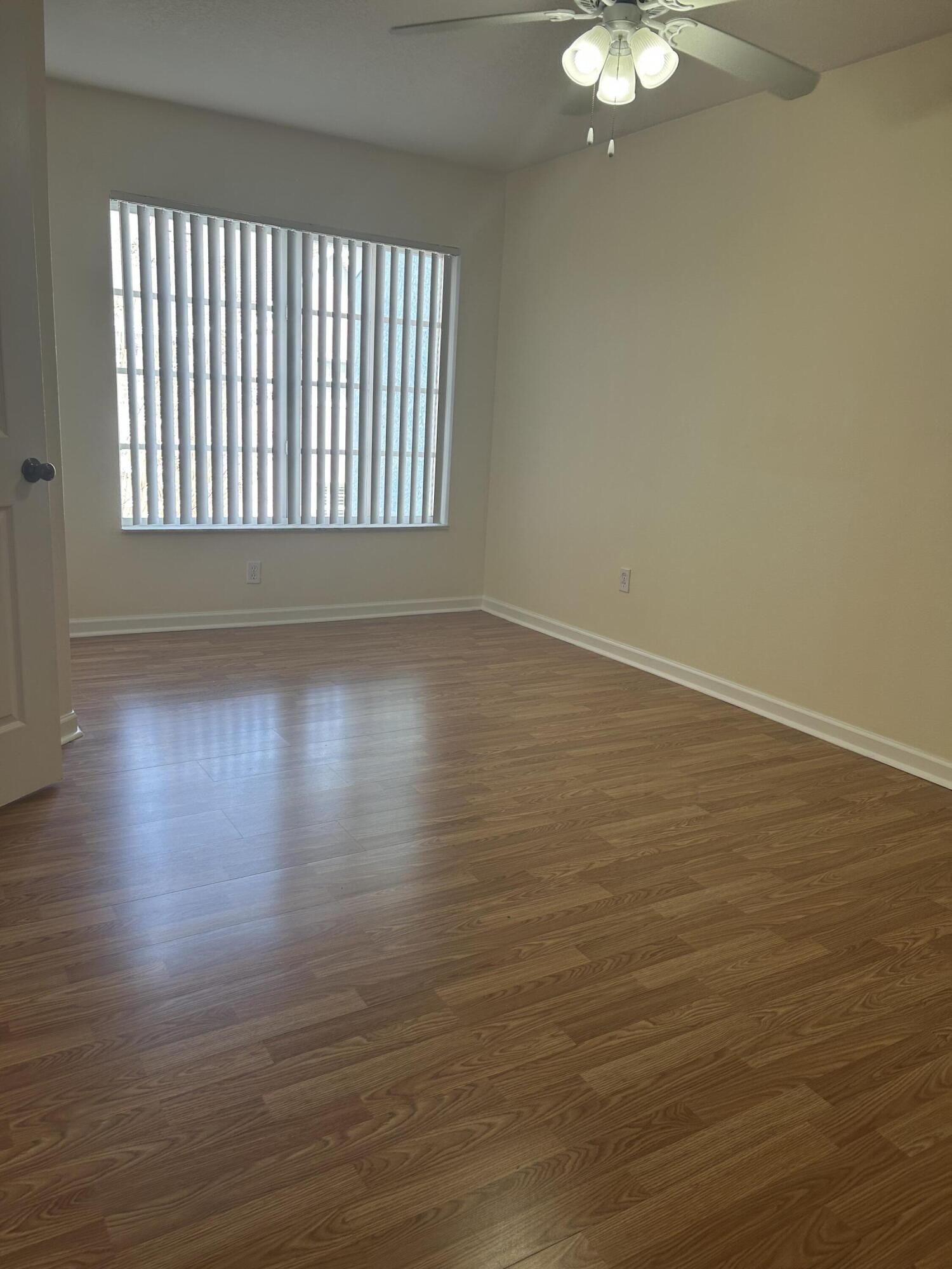 1687 Southeast Pomeroy Street Stuart, FL 34997 - Photo 13 of 20 a view of an empty room with wooden floor and a window
