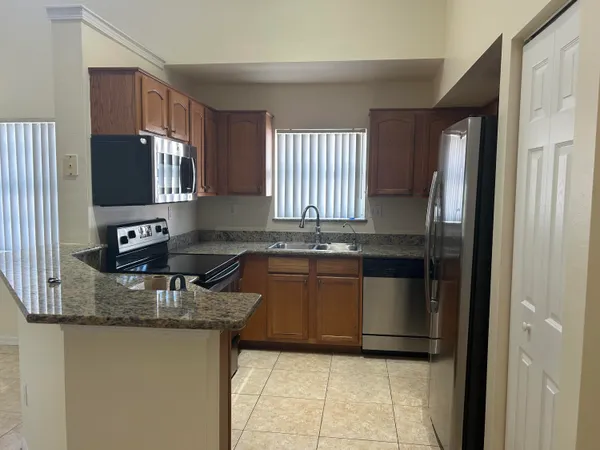 a kitchen with granite countertop a refrigerator and a sink