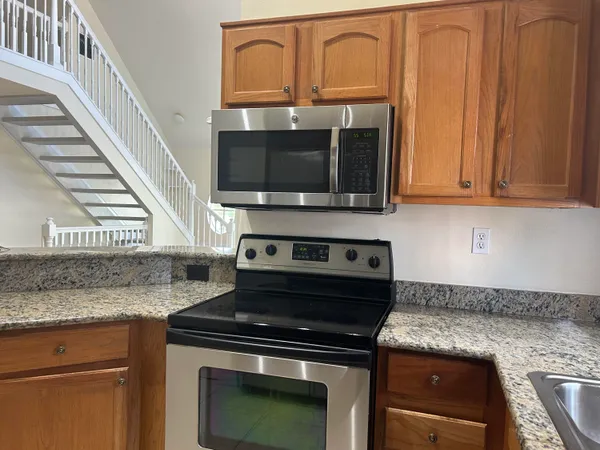 a kitchen with granite countertop a stove top oven cabinetry and granite counter tops